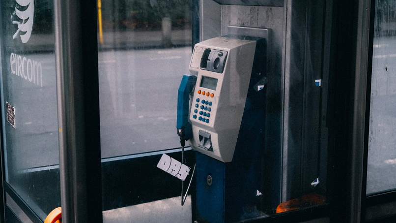 Image of a payphone inside a blue and silver booth